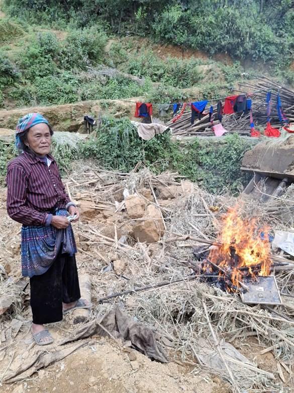 Bà của Thào Thị Nhé đang thu thập những kỷ vật còn lại của cha mẹ để đốt theo phong tục địa phương. Ảnh: NTCC.